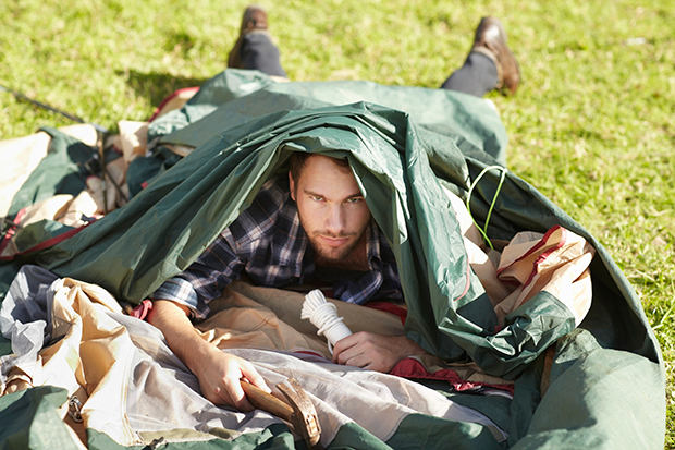 man exhausted from setting up tent