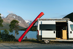 big red canoe next to small van