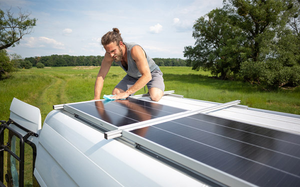 person cleaning solar panel