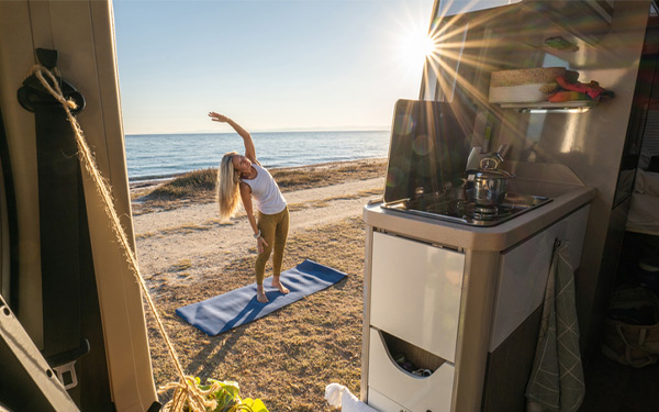 person outside their RV doing yoga to stay fit