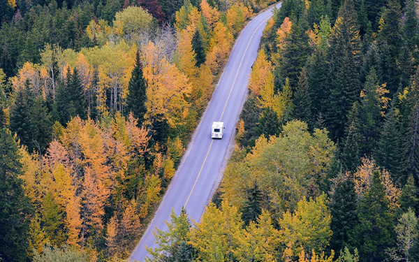 RV going down road in autumn