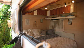 a camper home with a hanging shelf for RV storage
