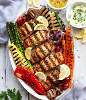 grilled salmon on a plate with grilled veggies