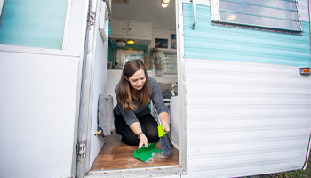 A person preparing to store their RV by cleaning the interior