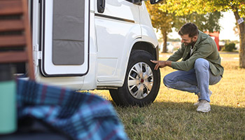person ensuring RV safety by checking their tires