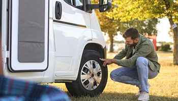 rv owner inspecting rv tires to prevent rv repairs