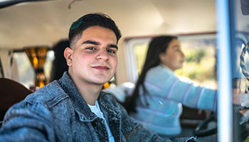 young man in passenger seat of van while friend is driving in baja