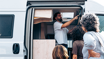 RV show sales man in 2026 showing camper van